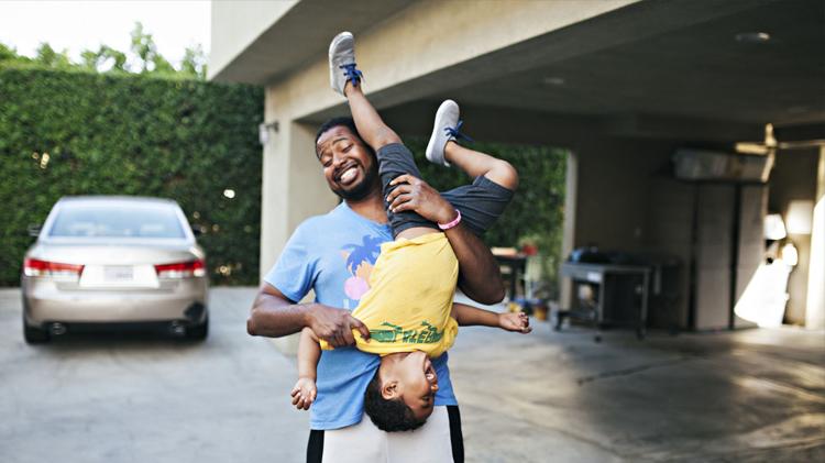 Dad and son having fun in the driveway.