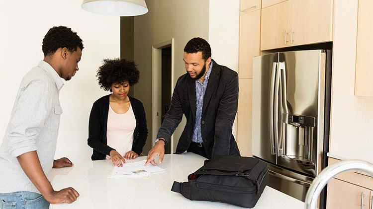 Couple reviewing a lease with a landlord.